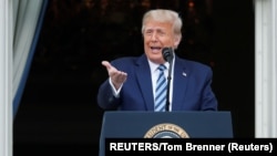 USA, Washington, U.S. President Donald Trump stands on a White House balcony speaking to supporters gathered on the South Lawn for a campaign rally