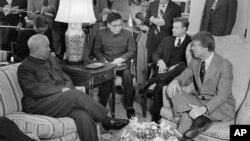 1977年2月8日，美国总统卡特及其国家安全顾问布热津斯基在白宫总统办公室会见中国驻美国联络处主任黄镇（前排左一）