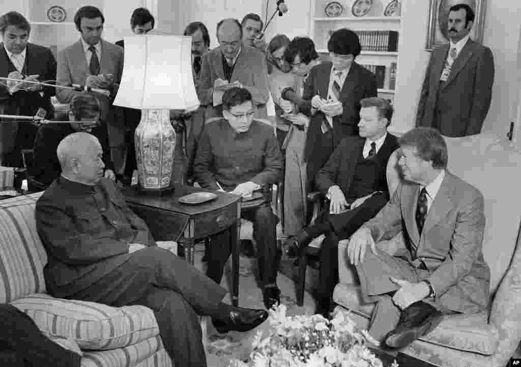 1977年2月8日，美国总统卡特及其国家安全顾问布热津斯基在白宫总统办公室会见中国驻美国联络处主任黄镇（前排左一）。站立者多为记者。 1978年5月布热津斯基访问北京的时候，卡特总统已经决意要与北京建立正式外交关系。 中国一直要求美国停止对台湾的一切武器销售，双方在军售问题上一直僵持不下。最终，邓小平对两国关系正常化后美国继续对台湾出售武器表示默许。两国于1979年1月1日正式建立外交关系