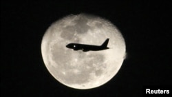 Một máy bay phản lực chở hành khách bay trước mặt trăng