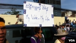 A protester holds a sign during an 20,000-strong rally organized by the Cambodia National Rescue Party on Saturday, September 07, 2013, a day before the official announcement, demanding an investigation into irregularities and an accurate reflection of voters whom it says were left out of the process.