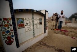 Mohammed Amin, left, offer prayers at a grave of his daughter Zainab in Kasur, Jan. 18, 2018.