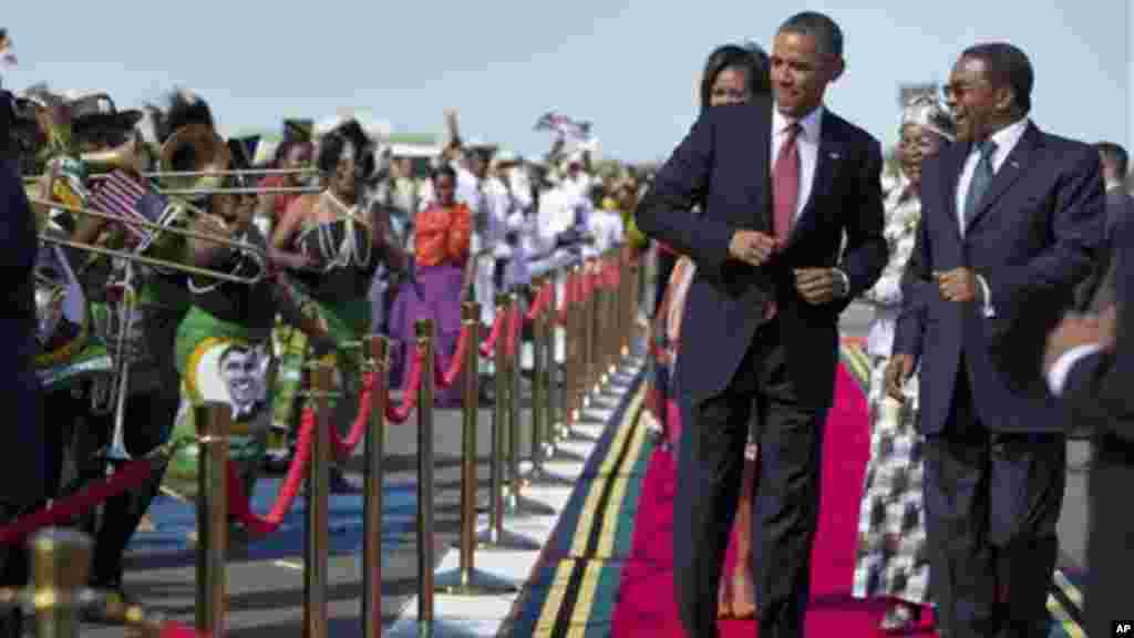 President Obama, followed by the first lady, does a dance upon his arrival ceremony with Tanzanian President Kikwete.