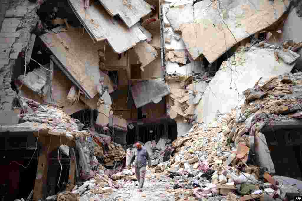 A man walks amid destruction in Aleppo, April 10, 2013.