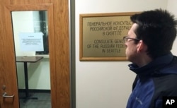 A person, who refused to give their name, checks a sign on the door of the Russian consulate office stating that the office is closed and not accepting any new passport applications in Seattle, Washington, March 26, 2018.