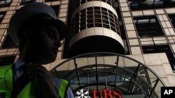 A security guard stands in front of a UBS bank in the City of London, September 15, 2011.