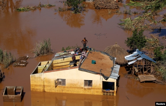 A man looks around from atop his house after Cyclone Idai in Buzi district outside Beira, Mozambique, March 22, 2019.