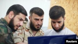 Zahran Alloush, centro, se encontraba junto a otros compañeros en una vivienda oculta que funcionaba como cuartel, en Guta Oriental, un suburbio de Damasco.