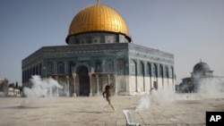 Mwanaume wa Kipalestina akikimbia mabomu ya machozi yaliyofyatuliwa wakati wa ghasia baina ya polisi wa Israeli na Wapalestina, Jerusalem, Jumatatu, Mei 10, 2021. (AP Photo/Mahmoud Illean)