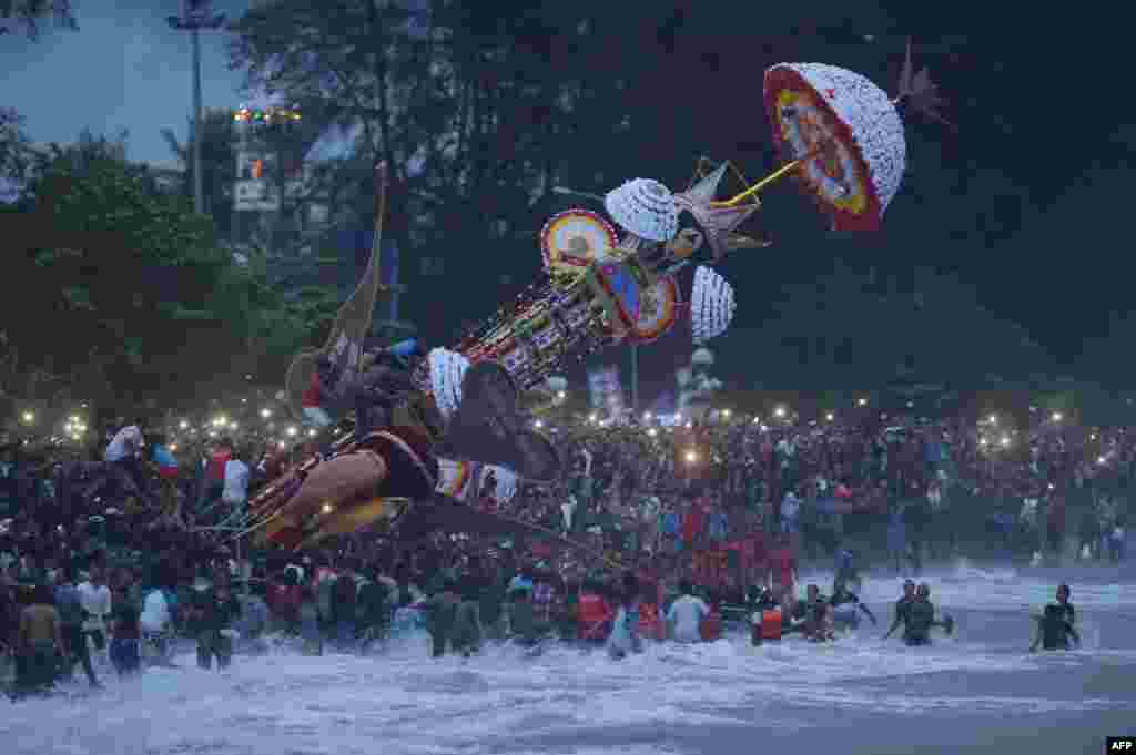 Indonesian Muslims cast a hoyak tabuik, a model of a mythical Islamic steed, into the sea during the Hoyak Tabuik festival in Pariaman on West Sumatra.