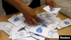Un agent électoral libanais compte les bulletins de vote après la fermeture des bureaux lors des élections municipales de Beyrouth au Liban, le 8 mai 2016.