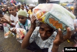 Rohingya migrants from Myanmar wait in line for food aid packages at a temporary shelter in Beyeun, in Indonesia's Aceh Province, May 31, 2015.