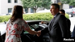 Turkish Deputy Foreign Minister Sedat Onal, right, shakes hands with a U.S. State Department protocol official after his meeting with Deputy Secretary of State John Sullivan at the State Department in Washington, Aug. 8, 2018.