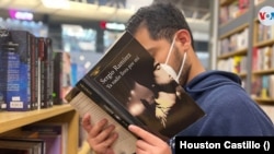 Un hombre hojea un libro del escritor Sergio Ramírez en una librería en Managua, Nicaragua. Foto Houston Castillo, VOA.