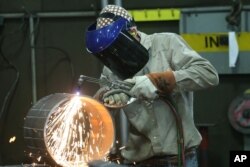 FILE - An employee welds pipe at Pioneer Pipe on Oct. 25, 2016 in Marietta, Ohio. The construction, maintenance and fabrication company employs around 800 people, supplying products to the oil and gas industry.