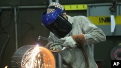 FILE - An employee welds pipe at Pioneer Pipe on Oct. 25, 2016, in Marietta, Ohio. The construction, maintenance and fabrication company employs around 800 people, supplying products to the oil and gas industry. 