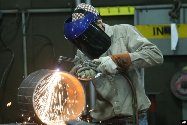 FILE - An employee welds pipe at Pioneer Pipe on Oct. 25, 2016 in Marietta, Ohio. The construction, maintenance and fabrication company employs around 800 people, supplying products to the oil and gas industry.