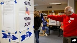 An election official directs voters on election day in McLean, Virginia on Nov. 5, 2013. (AP Photo/Jacquelyn Martin)