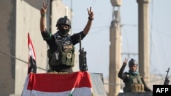Members of Iraq's elite counter-terrorism service flash the "V" for victory sign, Dec. 29, 2015 in the city of Ramadi, the capital of Iraq's Anbar province, about 110 kilometers west of Baghdad, after Iraqi forces recaptured it from the Islamic State (IS)