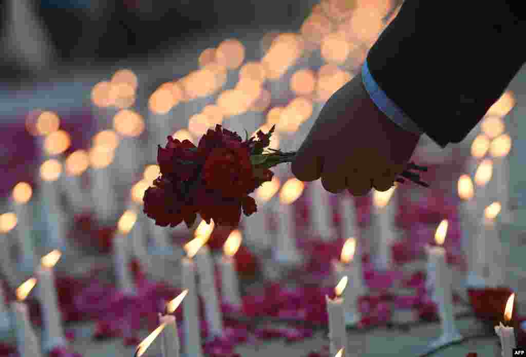 A Pakistani legislator places flowers at a memorial in Islamabad for the children and teachers killed by Taliban militants in army-run school in Peshawar on Tuesday.