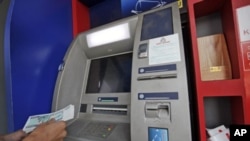 A man uses an ATM machine at KBZ bank's head office in Rangoon, March 14, 2012. 