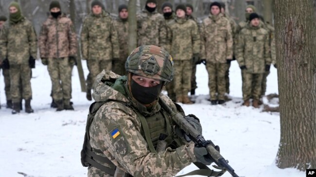 An instructor trains members of Ukraine's Territorial Defense Forces, volunteer military units of the Armed Forces, in a city park in Kyiv, Ukraine, Saturday, Jan. 22, 2022. (AP Photo/Efrem Lukatsky)