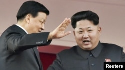 지난 13일 북한 평양에서 열린 노동당 창건 70주년 기념식에서 김정은 국방위원회 제1위원장(오른쪽)이 중국 대표단을 이끌고 방북한 류윈산 공산당 정치국 상무위원과 함께 열병식을 참관하고 있다.