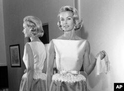 FILE - In this April 6, 1962, photo, socialite-actress Dina Merrill models the gown she was to wear at the Academy Awards presentation in Los Angeles. Merrill, the rebellious heiress who defied her super-rich parents to become an actress, died May 22, 2017, at age 93.