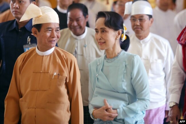 រូបឯកសារ៖ អតីត​ប្រធានាធិបតី​មីយ៉ាន់ម៉ា លោក Win Myint (ឆ្វេង) និង​អ្នកស្រី Aung San Suu Kyi អញ្ជើញ​មក​ដល់​សភា​ជាតិ​ក្នុង​រដ្ឋធានី​ណៃពិដោ​ដើម្បី​ស្បថ​ចូល​កាន់​តំណែង កាល​ពី​ថ្ងៃ​ទី​៣០ ខែ​មីនា ឆ្នាំ​២០១៨។ (AFP)