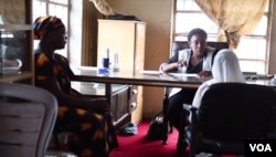 Mercy Philip (left) with her 8-year-old daughter (right in white) meet with a lawyer in northern Nigeria.