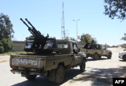 Gun-mounted vehicles belonging to fighters loyal to the internationally recognized Libyan Government of National Accord (GNA) are pictured near a military compound in a suburb of the capital Tripoli on April 9, 2019.