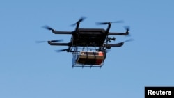 FILE - A drone demonstrates delivery capabilities from the top of a UPS truck during testing in Lithia, Florida, Feb. 20, 2017.