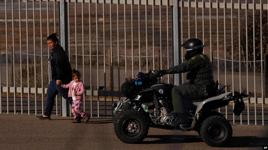 Archivo - Rachel Rivera, migrante hondureña de 19 años, y su hija, Charlot Andrea, de 3 años, caminan a lo largo de la valla fronteriza en San Ysidiro, California, tras entregarse a agentes de la Patrulla Fronteriza de EE.UU. el 4 de diciembre de 2018.