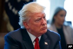 FILE - President Donald Trump listens in the Cabinet Room of the White House in Washington, March 29, 2017.