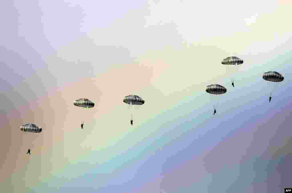 Pasukan payung Rusia melompat dari pesawat dengan latar belakang pelangi di angkasa selama latihan gabungan militer &ldquo;Persaudaraan Slavia&rdquo; antara Rusia, Belarusia, dan Serbia di lahan latihan militer Kovin, dekat Beograd.