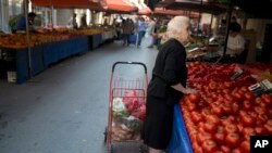 FILE - A elderly woman shops in Athens on July 3, 2015. Europe is the continent most affected by an aging population, and Spain has recorded more deaths than births in the first half of 2015. 