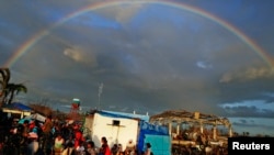 A rainbow appears above Typhoon Haiyan survivors at the Tacloban airport. 