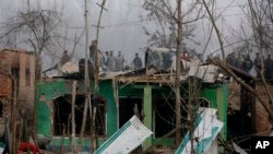 Penduduk desa di kawasan Mujagund, 25 kilometer dari Srinagar, daerah Kashmir yang dikontrol India, mengamati rumah-rumah mereka yang rusak akibat bentrokan senjata, 9 Desember 2018. (Foto: dok). 