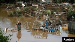 Čovek hoda kroz vodu u poplavljenoj oblasti u Nemačkoj (Foto: Reuters/Wolfgang Rattay)