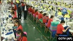 资料图：中国央视播放的这个没有标注日期的视频新闻显示，维吾尔学员在和田职业教育培训中心的一间制衣厂工作。 