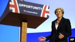 La primera ministra británica Theresa May hace un intento de bailar al llegar con acompañamiento musical al cónclave de su partido en Birmingham, Inglaterra el 3 de octubre del 2018. 