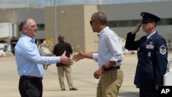 President Barack Obama reaches to shake hands with Louisiana Gov. John Bel Edwards, after arriving on Air Force One at Baton Rouge Metropolitan Airport in Baton Rouge, Louisiana., Aug. 23, 2016.