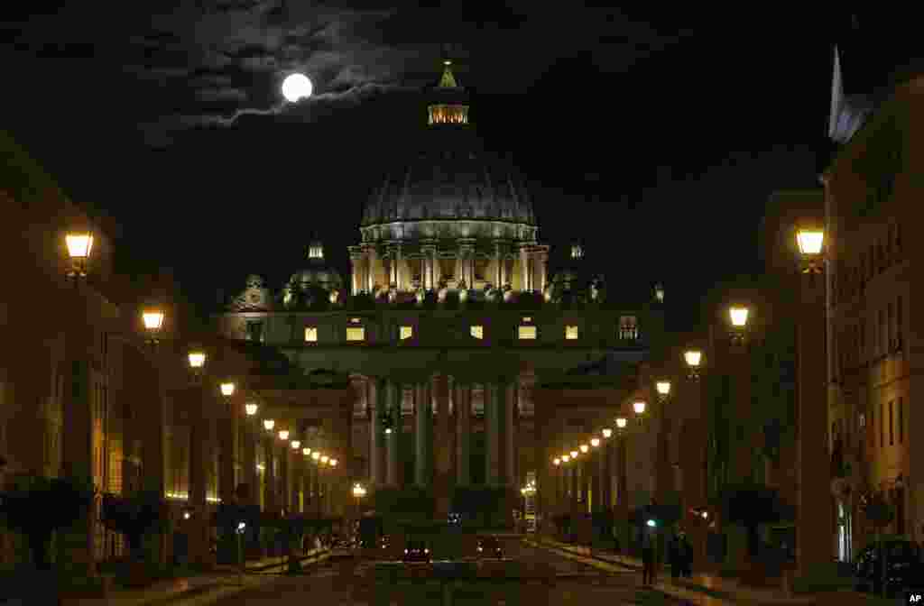 The full moon is seen above the St. Peter, Basilica at the Vatican.