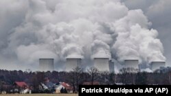 In this January 6, 2019 file photo water vapor rises from the cooling towers of the Joenschwalde coal-fired power plant of Lausitz Energie Bergbau AG (LEAG) in Brandenburg, Germany. (Patrick Pleul/dpa via AP)
