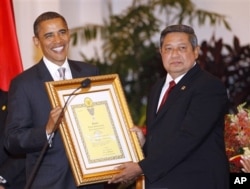 Le président Obama acceptant une distinction décernée par les autorités indonésiennes à sa défunte mère, Stanley Ann Dunham, pour son travail en Indonésie