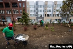 Volunteers work on the Viaduct Rail Park in Philadelphia. The new public green space is transforming a rusting, overgrown and abandoned rail line into an elevated park.