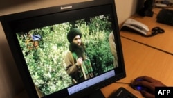 FILE - A Pakistani journalist watches a newly released video of radical cleric Maulana Fazlullah in Peshawar, July 23, 2010. 