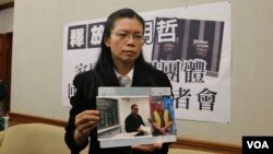 李明哲的妻子李净瑜2017年3月向媒体展示李明哲以往活动的照片 (资料照片) 
