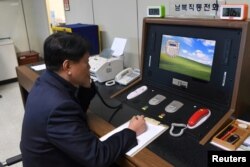 A South Korean government official checks the direct communications hotline to talk with the North Korean side at the border village of Panmunjom, Jan. 3, 2018.