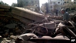 Men inspect scene of a car bombing in Qamishli, a remote, predominantly Kurdish area 497 miles northeast of Damascus, Syria, Sept. 30, 2012 (SANA via AP).